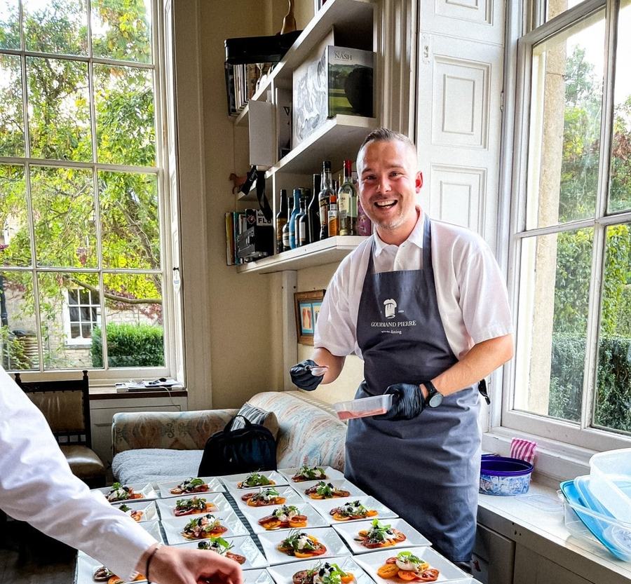 Private chef from Gourmand Pierre plating a row of tomato and burrata starters at a dinner party